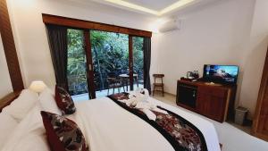 a bedroom with a bed with a stuffed animal on it at Asna House in Ubud