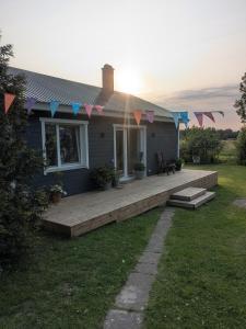 a house with a deck with flags on it at Peedu saunamaja in Hiiumaa