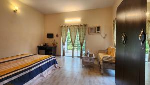 a bedroom with a bed and a chair and a window at Green County Wellness Retreat in Memāri +100 photos