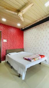 a bedroom with a bed with a red wall at Vamoose Kaas Hill Resort in Kanera