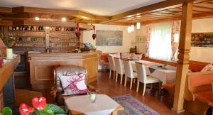 a restaurant with a bar and a table and chairs at Pension Krakolinig in Pörtschach am Wörthersee