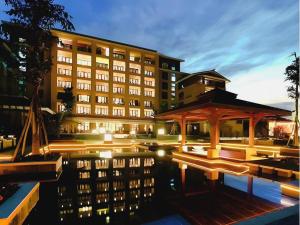 a building with a pool in front of a building at Xinjin Celebrity City Hotel in Xinjin