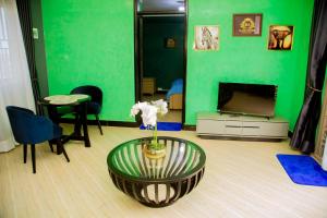a living room with a green wall and a coffee table at Blaize Affaire apartments in Kampala