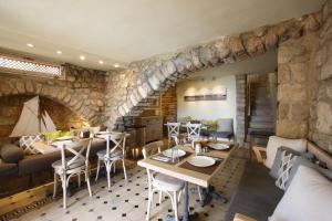 ein Restaurant mit Steinmauer, Tischen und Stühlen in der Unterkunft Dar Alma in Tyros