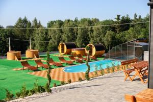 a patio with chairs and a swimming pool at Zielona Osada Apartamenty in Ciężkowice