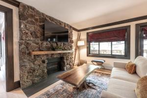 a living room with a stone fireplace and a couch at New Listing 3 BR 3 BA Aspen Condo near Gondola in Aspen