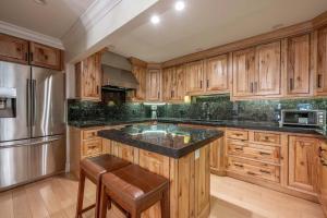 a kitchen with wooden cabinets and a black counter top at New Listing 3 BR 3 BA Aspen Condo near Gondola in Aspen +59 photos