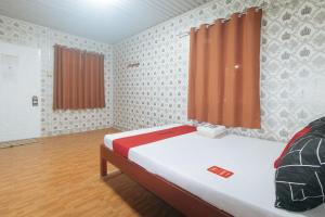 a small room with a bed and a window at RedDoorz @ Boondocks Cabins Resort in Dalumpinas Oeste