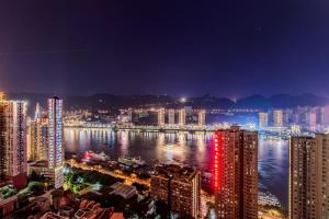 a city skyline at night with a river and buildings at 云深处江景公寓 in Chongqing