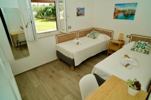 a small room with two beds and a table at Villa RiRò Bari in Bari