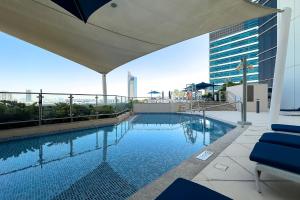 a swimming pool on the roof of a building at Fabulous 2BR Apartment with Palm View in Media City in Dubai
