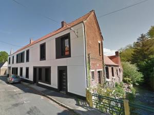 a white building with a door on the side of a street at Au fil de l'eau - Balcon, Spacieux, Confort, Calme, Wifi in Camblain-Châtelain