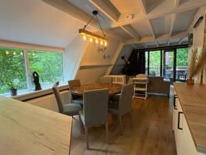 een keuken en eetkamer met een tafel en stoelen bij Chalet Séquoia 138 Nature, piscine et chien bienvenu à Durbuy in Durbuy