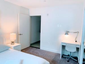 a bedroom with a bed and a desk and a lamp at Western Lemon Grove in Los Angeles