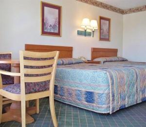 a bedroom with a bed and a desk and a chair at America's Best Inn - Brinkley in Brinkley