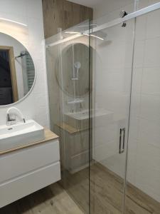 a bathroom with a glass shower and a sink at Apartament 26 Gdynia Zachód in Gdynia
