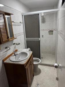 a bathroom with a shower and a sink and a toilet at Casa del parque in Bello +3 photos