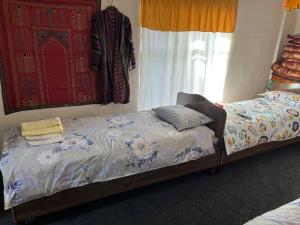 a bedroom with two beds and a window at ХОСТЕЛ ТаСмИн МеХр РеГиСтАн in Samarkand +15 photos