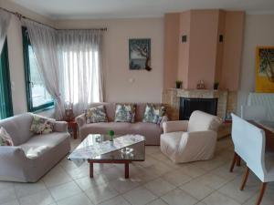 a living room with white furniture and a fireplace at Villa Rodia in Potos