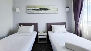 Postelja oz. postelje v sobi nastanitve Amansari Hotel Nusajaya