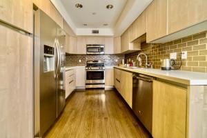 a kitchen with wooden floors and stainless steel appliances at Western Melrose in Los Angeles