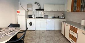 a kitchen with white appliances and a table with chairs at Casa Daymar 2 Mai in 2 Mai