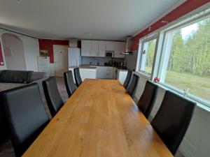 a long wooden table and chairs in a kitchen at Villa Björklund - Lakeview Apartment in Swedish Lapland in Arjeplog