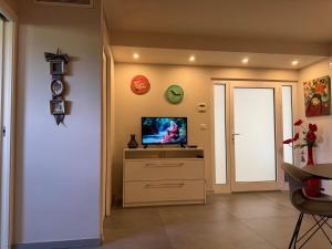 a living room with a television on a dresser at Cannes, Mougins, Sophia-Antipolis, Grasse, Nice, Monaco, Saint-Tropez in Mougins