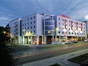 a large white building on a city street at night at Ibis Szczecin Centrum in Szczecin