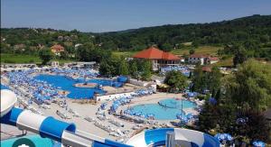a resort with two pools with chairs and people in them at Harizma lux centar in Popadić