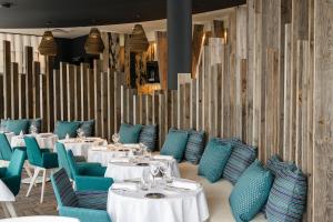 a restaurant with white tables and blue chairs at Thalazur Arcachon in Arcachon