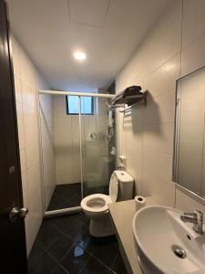a bathroom with a shower and a toilet and a sink at Homestay in Marina Heights with beach view in Lumut
