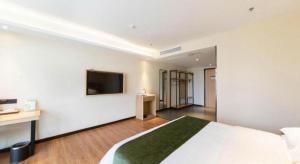 een hotelkamer met een bed en een flatscreen-tv bij GreenTree Inn Lu'an Jin'an District Yuanda Xingfuli in Chengdong