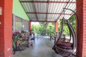 a patio with a swing and tables and a building at OYO 75372 Flight hut hotel in Hua Hin