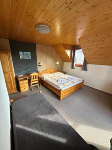 a bedroom with a bed and a wooden ceiling at Penzión Patrik in Ždiar