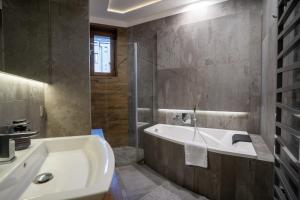 a bathroom with a bath tub and a sink at Zabrska 18 Spacious Apartment by BookingHost in Katowice +17 photos