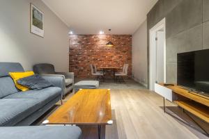 a living room with a couch and a table at Zabrska 18 Spacious Apartment by BookingHost in Katowice