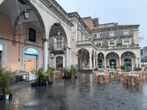 cortile con tavoli e sedie in un edificio di Holiday Home Guglielmo a Catania