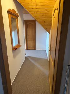 an empty hallway with a wooden ceiling and a door at Penzión Patrik in Ždiar