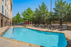 a swimming pool with chairs and a building at Hampton Inn and Suites Trophy Club - Fort Worth North in Trophy Club