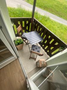 Un patio con una mesa y sillas en un balcón. en Apartmán Na Manhattanu, en Rokytnice nad Jizerou