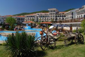 a carriage in front of a resort with a pool at KAMBANI BELLS Apart Complex in Sveti Vlas