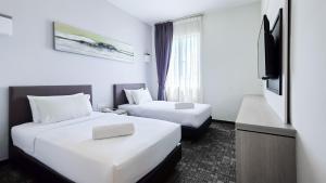 Postelja oz. postelje v sobi nastanitve Amansari Hotel Nusajaya