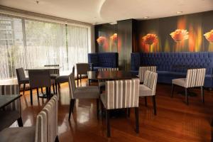 un ristorante con tavoli e sedie e un divano blu di Radisson Hotel Decapolis Miraflores a Lima
