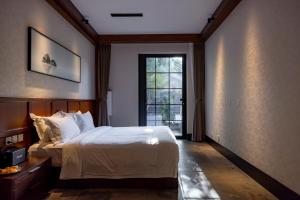 北京YiPiao Courtyard Hot Spring Resort Xiaotangshan Beijing的一间带大床和窗户的卧室 更多27张照片