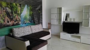 a living room with a couch and a flat screen tv at Black & White in Burgas