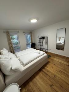 a bedroom with a large white bed and a mirror at Prestige Apartments - Urban Lofts Reutlingen in Reutlingen