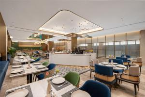 a rendering of a restaurant with tables and chairs at Hilton Garden Inn Taizhou Xinghua in Xinghua