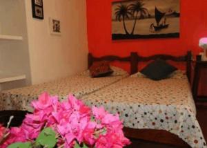 um quarto com uma cama com flores cor-de-rosa em Pousada 100 Passos em Tamandaré