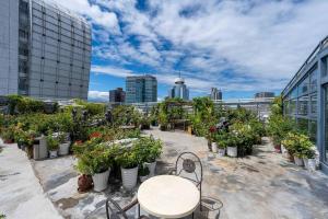 a table and chairs on a balcony with potted plants at Beijing AC Art Museum Hotel in Beijing +37 photos